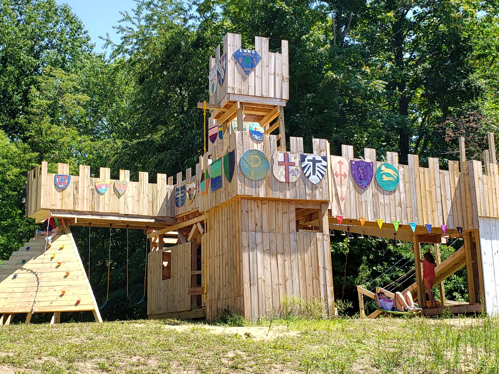 Custom castle-themed play structure with climbing wall and slide