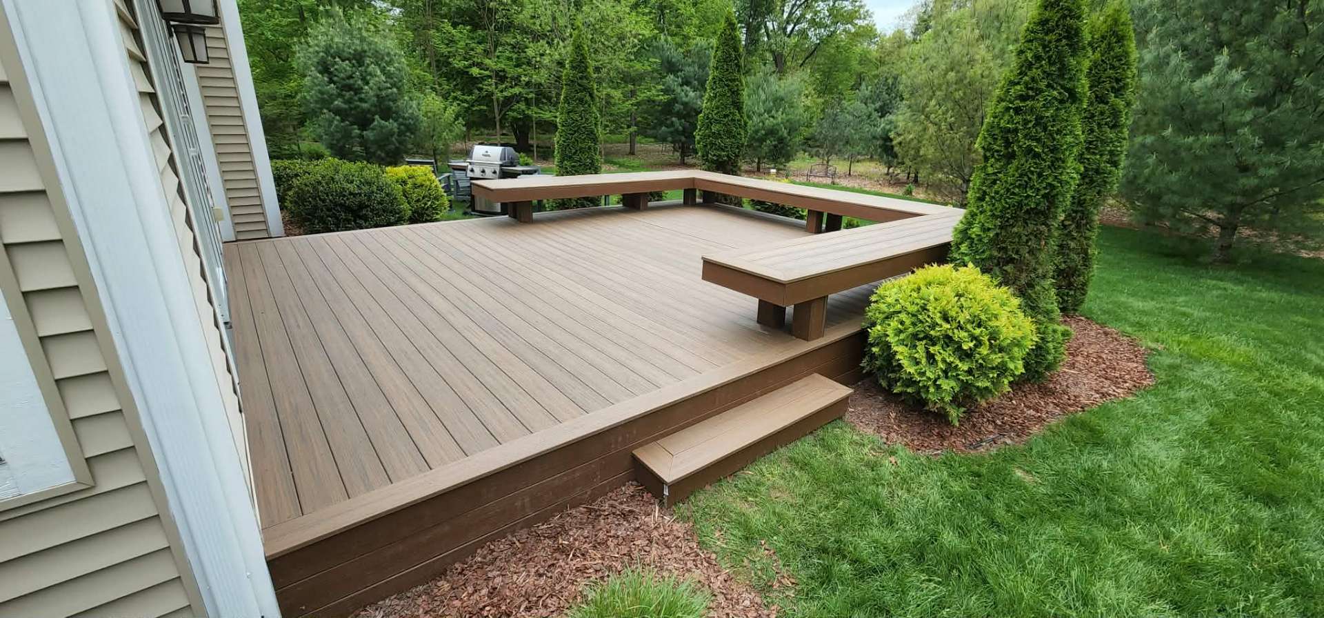 Composite deck with built-in bench seating and planter boxes
