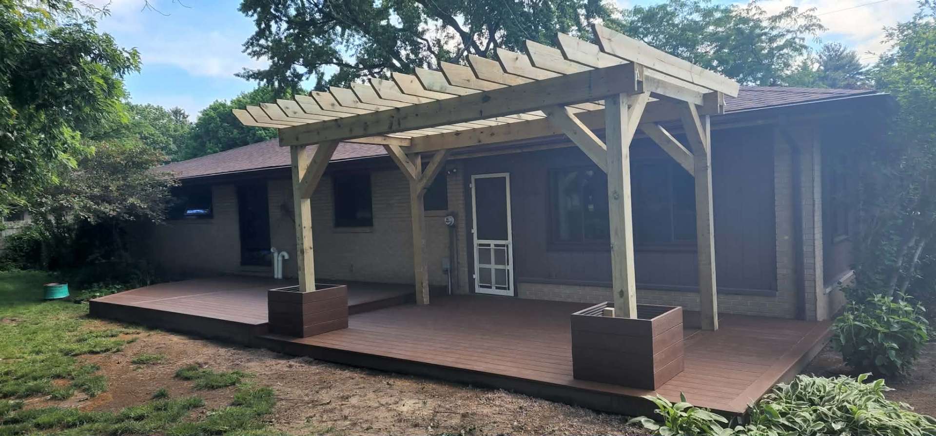 Pergola attached to a composite deck with outdoor seating area